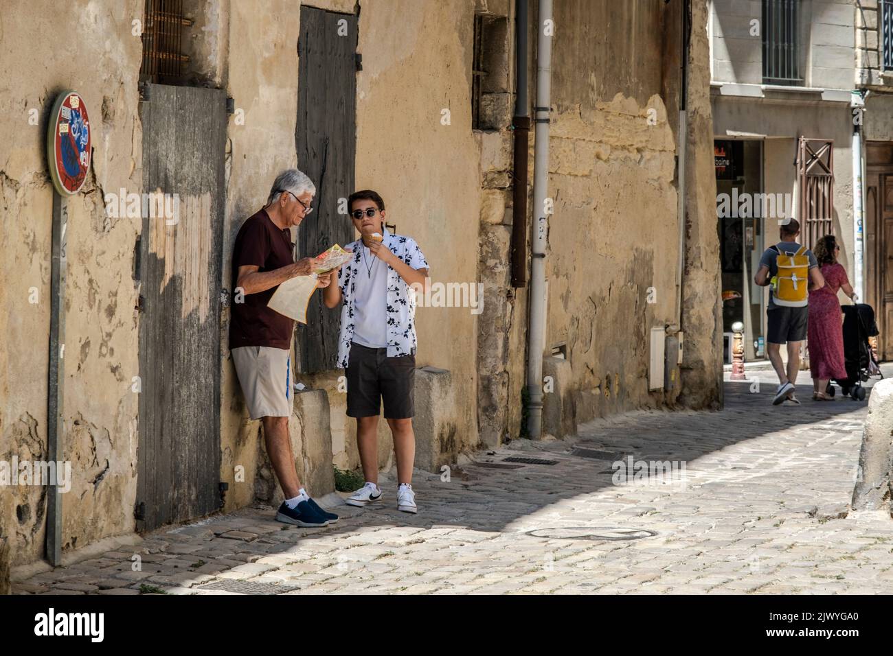 Persone che camminano per le strade nel centro di Uzes, Francia Foto Stock
