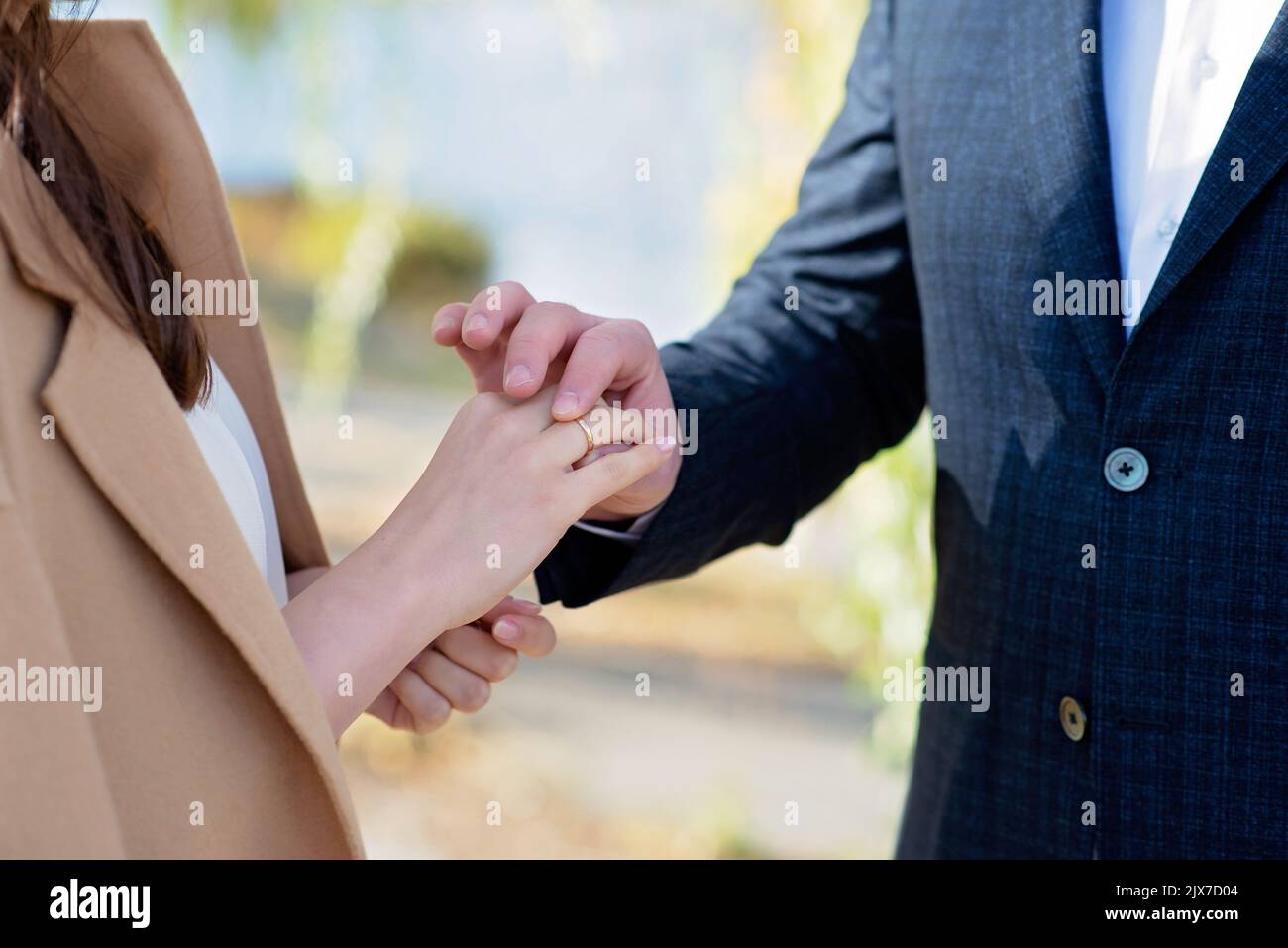 Sposarmi oggi e tutti i giorni, mani di una coppia eterosessuale di nozze. Lo sposo mise l'anello sul dito della sua bella moglie. Messa a fuoco selettiva morbida Foto Stock