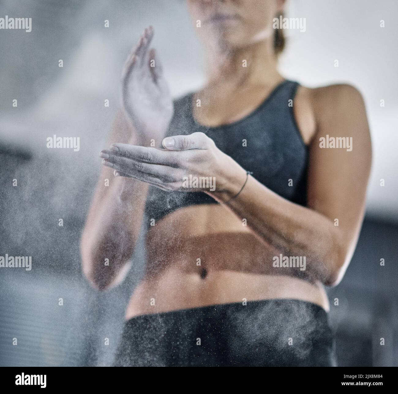 Il successo inizia con la disciplina. Un atleta femminile che le riveste le mani con gesso sportivo. Foto Stock