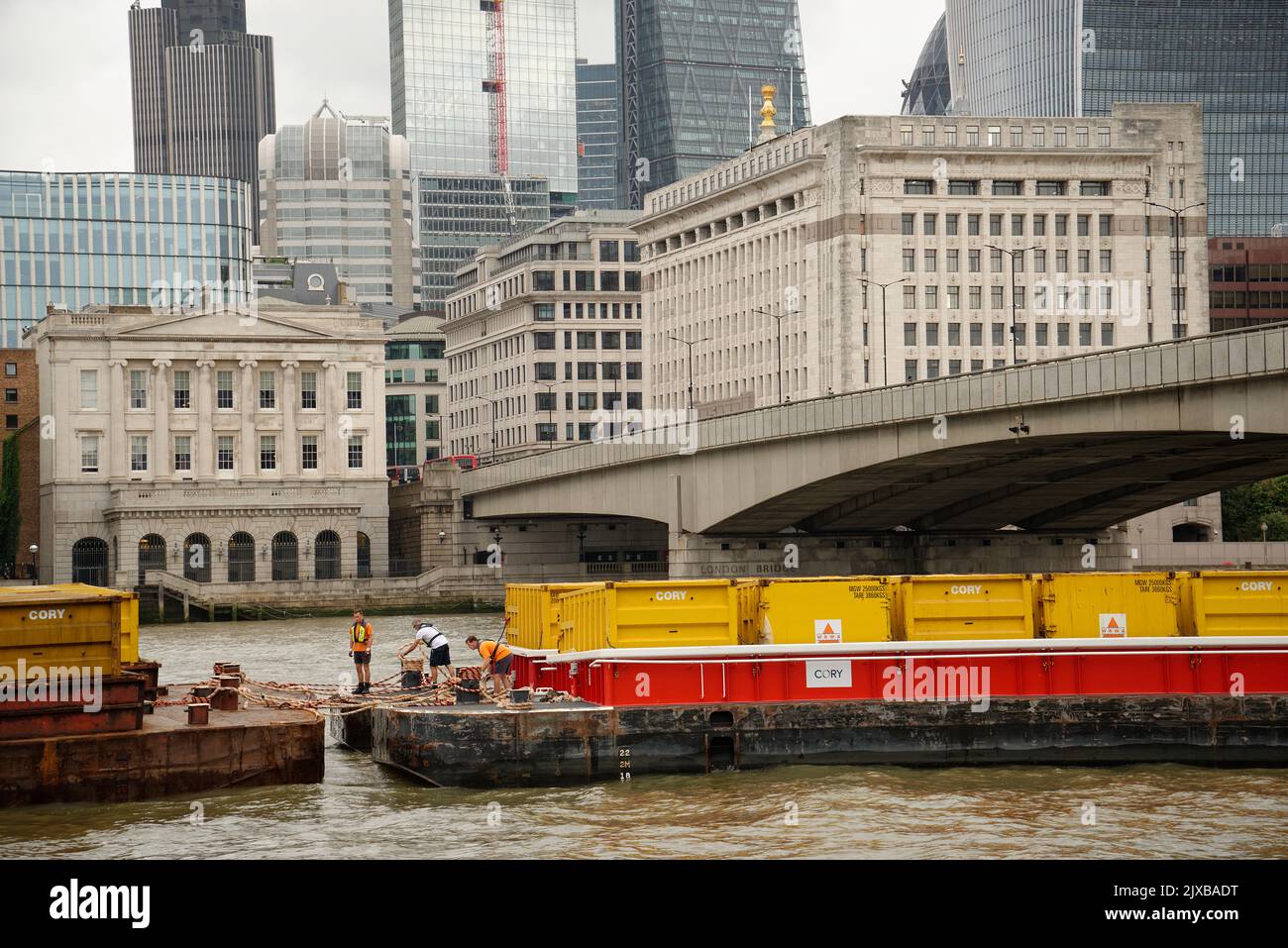 La città di Londra con chiatte piene di container sul Tamigi. Foto Stock