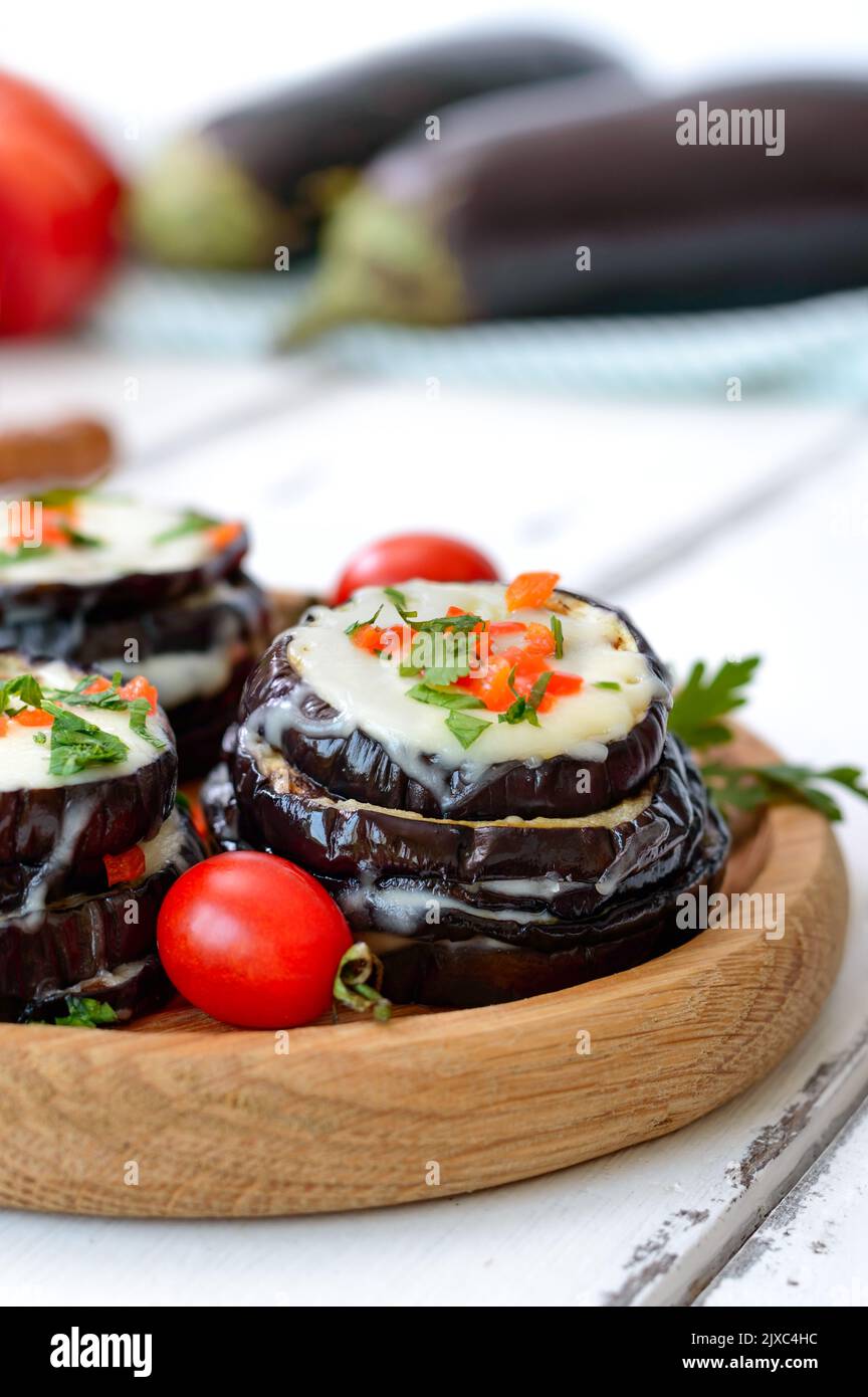 Melanzane al forno, pomodori e formaggio sul tavolo. Vista verticale Foto Stock