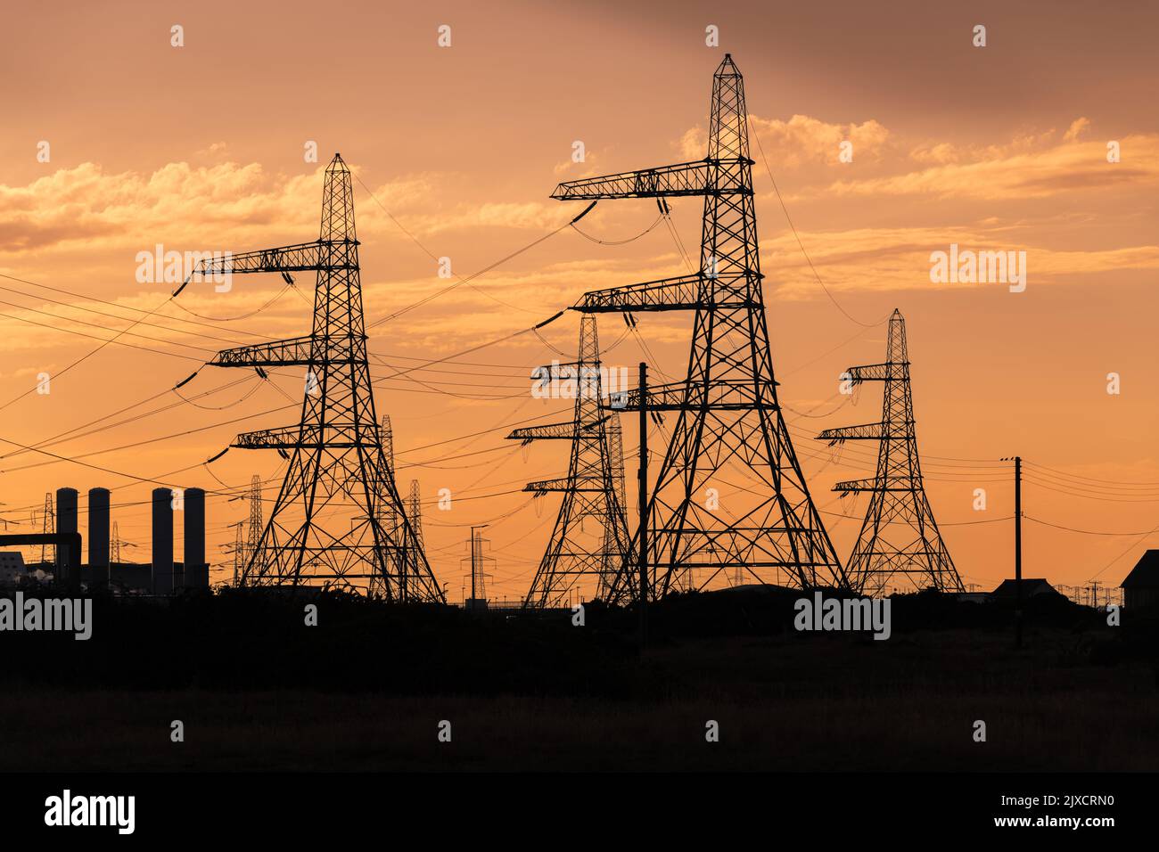 Linee elettriche ad alta tensione in uscita dalla centrale nucleare di Dungeness. Mentre la crisi energetica intensifica alcune centrali elettriche britanniche entrambe alimentate a carbone Foto Stock