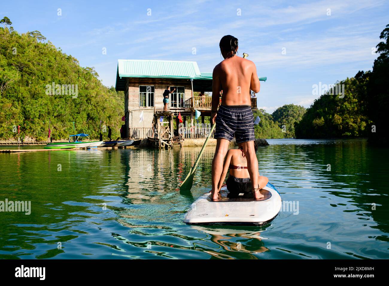 Giovane coppia in canoa nella laguna al mattino, godendo la vista. Sugba Bay a Siargao, Filippine Foto Stock