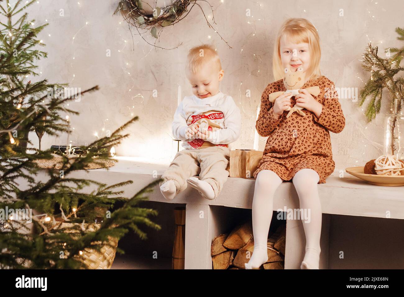 Piccolo fratello e sorella giocano la vigilia di Natale in una bella casa  decorata per le vacanze di Capodanno. I bambini giocano con un regalo di  Natale Foto stock - Alamy