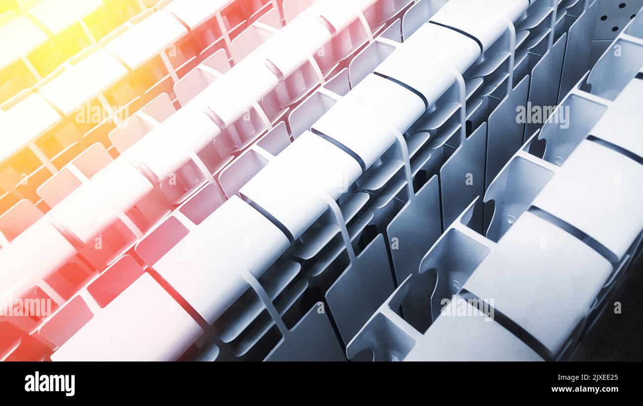 Molti radiatori riscaldanti in alluminio bianco o bimetallici si trovano uno accanto all'altro su un supporto in un negozio. Freddo e caldo Foto Stock