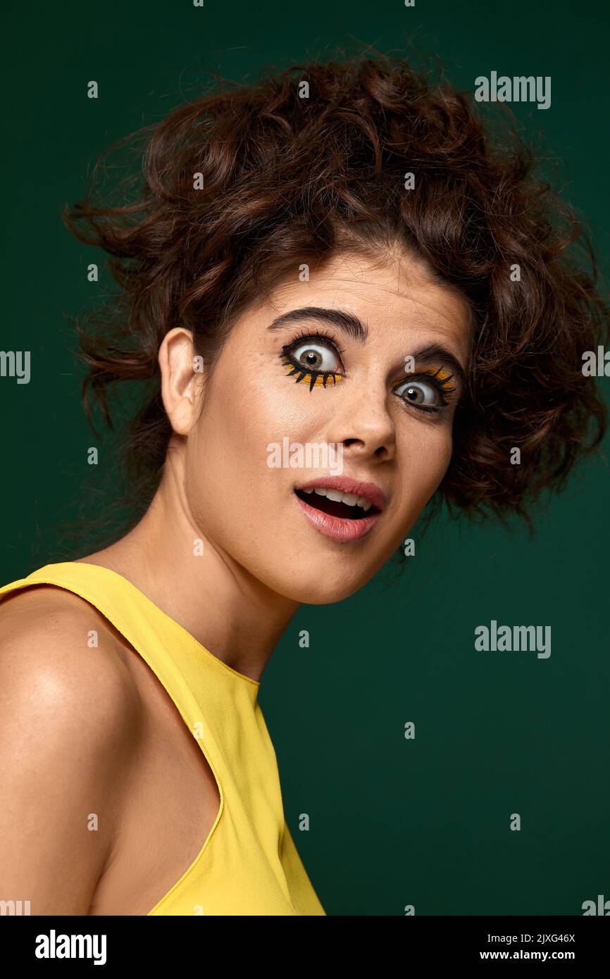donna ricciola spaventa con make-up creativo in abito giallo Foto Stock