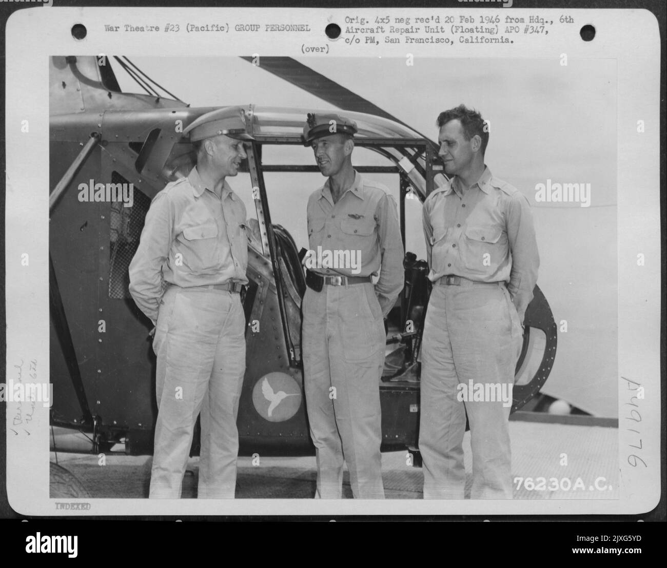 Brig. Generale James F. Phillips (sinistra) Chat con due ufficiali della 6th unità di riparazione di aeromobili (galleggiante) accanto A Un elicottero a bordo di nave da qualche parte nel Pacifico, 28 agosto 1945. [Sikorsky R-4] Foto Stock