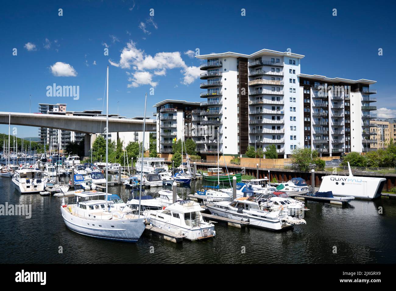 Barche contro un cielo blu vicino agli appartamenti di Atlantic Wharf nel fiume Ely a Cardiff, Galles, Regno Unito. Foto Stock