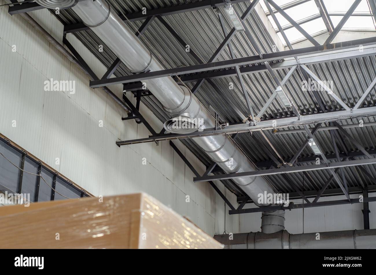 Soffitto di un grande edificio di fabbrica con illuminazione artificiale. Background industriale Foto Stock