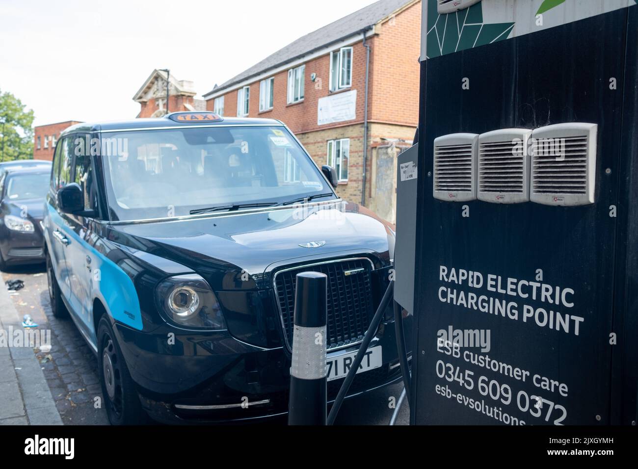 Londra - Agosto 2022: Taxi elettrico di Londra presso un punto di ricarica rapida elettrica al largo di Streatham High Road nel sud-ovest di Londra Foto Stock