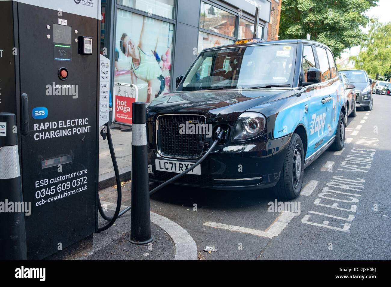 Londra - Agosto 2022: Taxi elettrico di Londra presso un punto di ricarica rapida elettrica al largo di Streatham High Road nel sud-ovest di Londra Foto Stock