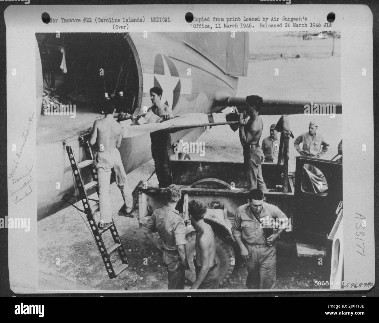 Isole Caroline, 12 ottobre 1944. Uno dei primi 60 Marines feriti ad essere evacuati da tre Curtiss C-46 Commando Hospital aerei è messo a bordo presso l'Airfield su Peleliu. Un camion raddoppiò come ambulanza per portare alcuni dei feriti all'Airbas Foto Stock