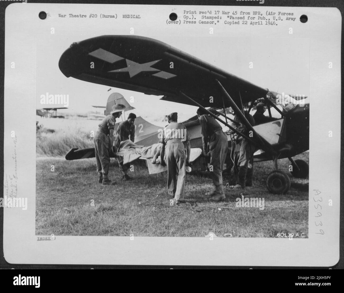Birmania - 27 Gen 45 - il Soldato britannico ferito viene caricato sull'aereo Vultee L-5 per essere volato in India per un'operazione di emergenza. Fu ferito a Ramree Island e aveva entrambi i piedi frantumati da mortaio fuoco e Un proiettile nel suo cervello. Foto Stock