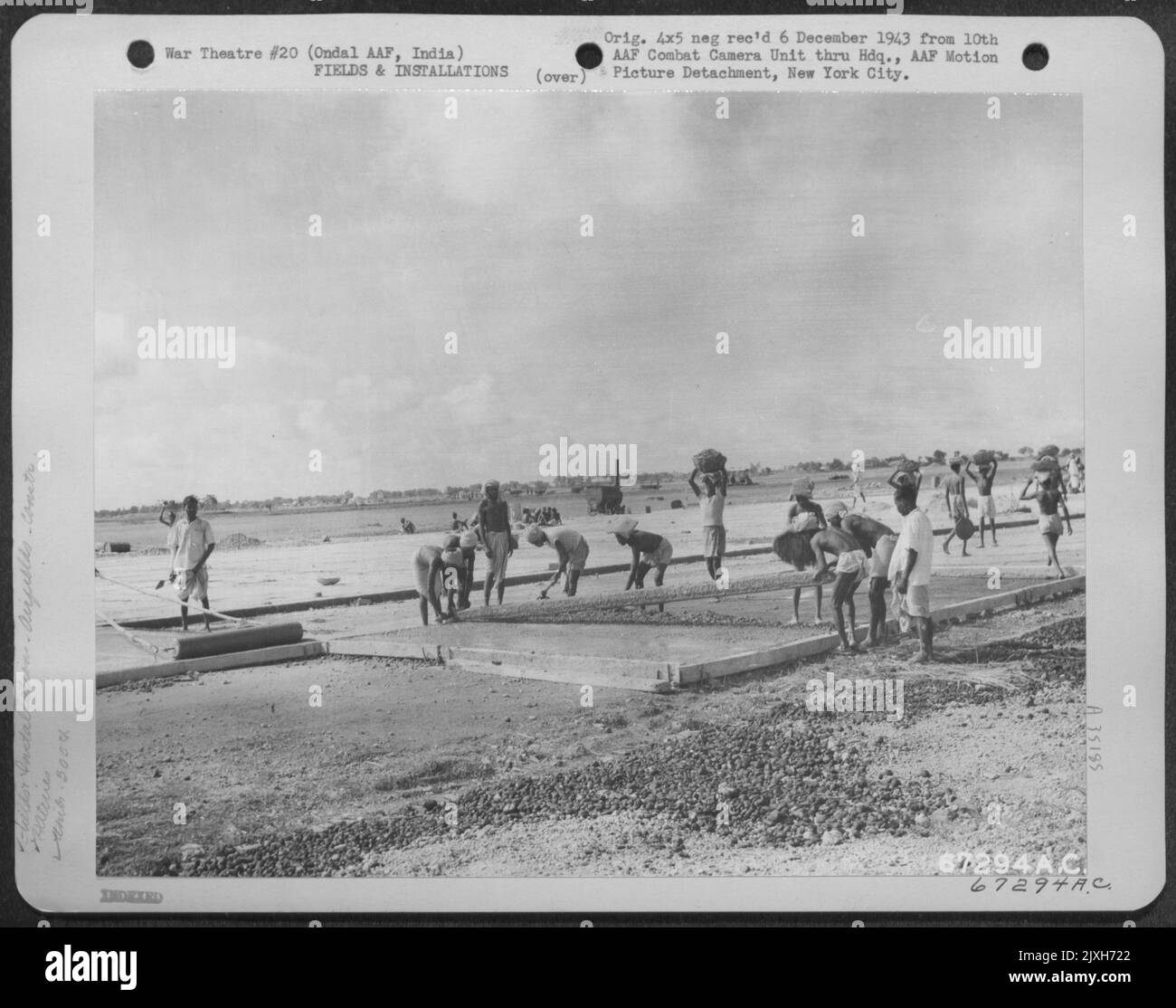 Senza la convenienza di Modern Equipment, i nativi posano cemento durante la costruzione di Una pista alla base aerea dell'esercito di Ondal in India. Il progetto era sotto la supervisione del Gruppo di servizi 305Th. 1943. Foto Stock
