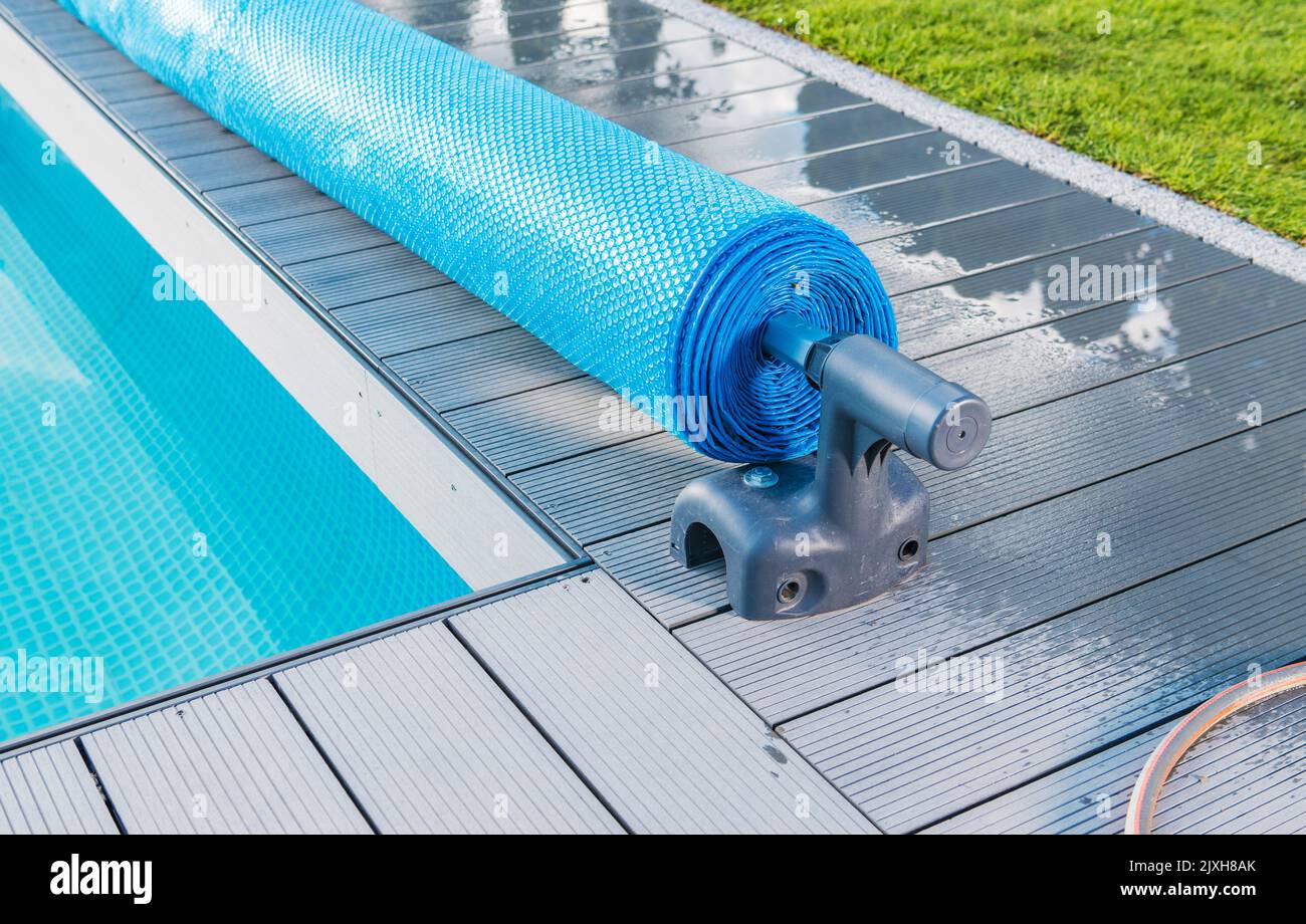 Manuale piscina esterna coperta solare rullo di copertura o rullo di copertura rullo di bobina di chiusura. Temperatura e pulizia dell'acqua di manutenzione. Foto Stock