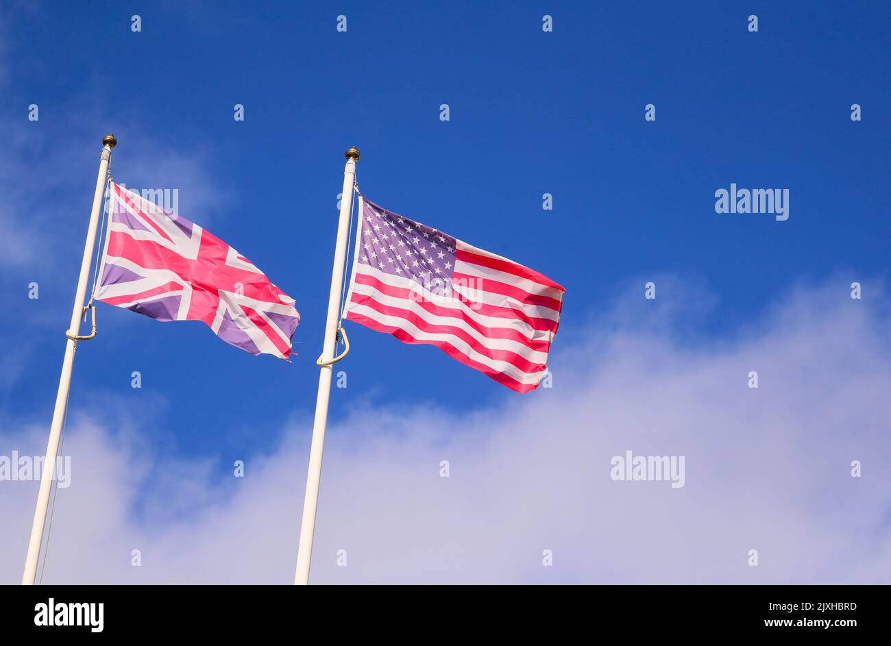 Le bandiere del Regno Unito e degli Stati Uniti d'America sorvolano un cielo blu a Belfast, Irlanda del Nord. Foto Stock