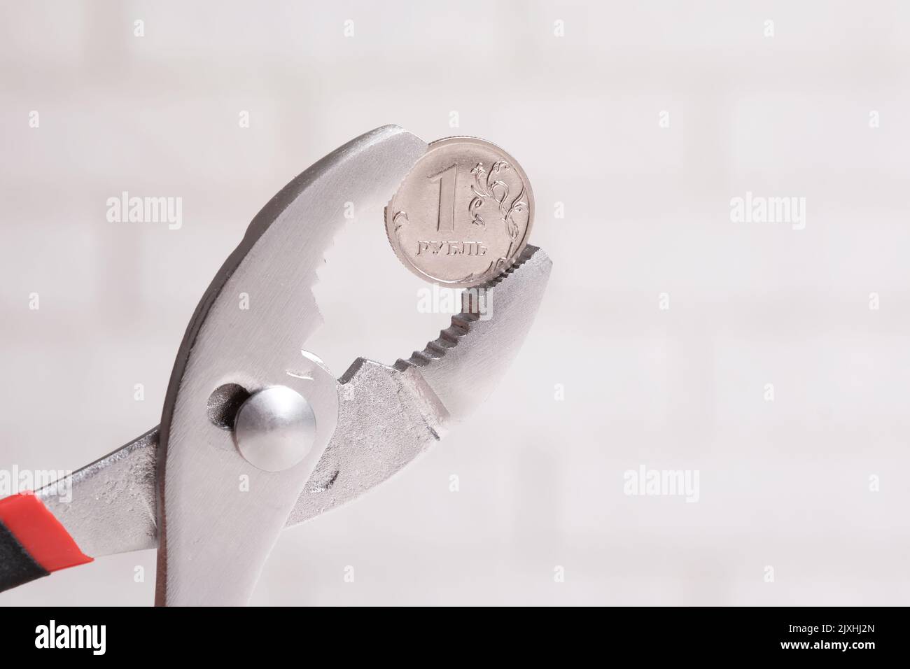 Un rublo russo e pinze, una moneta russa rublo in metallo pinze, Russia crisi concetto Foto Stock