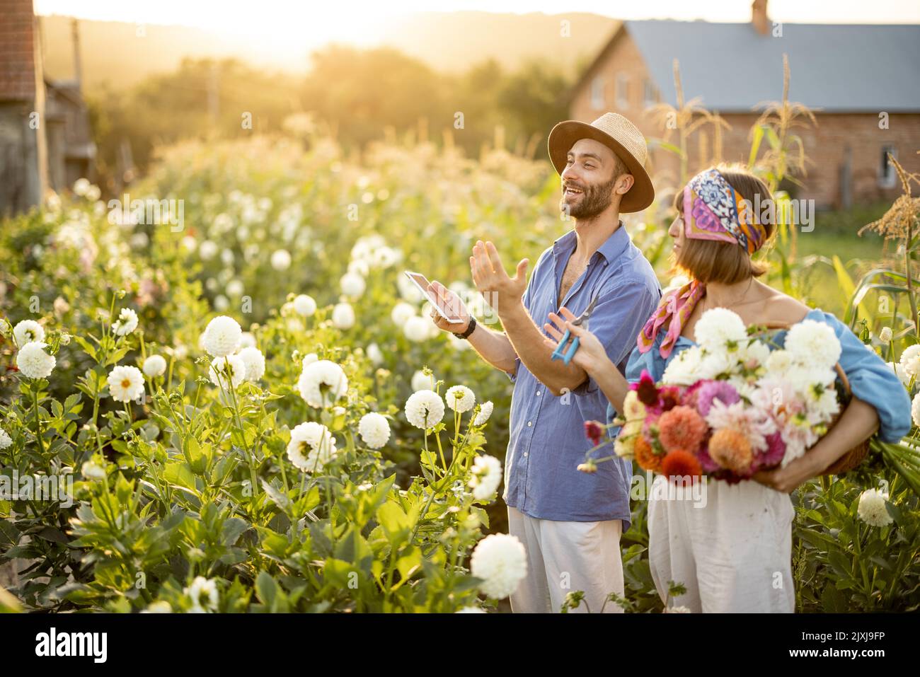 Gli agricoltori lavorano all'aperto in una fattoria di fiori Foto Stock