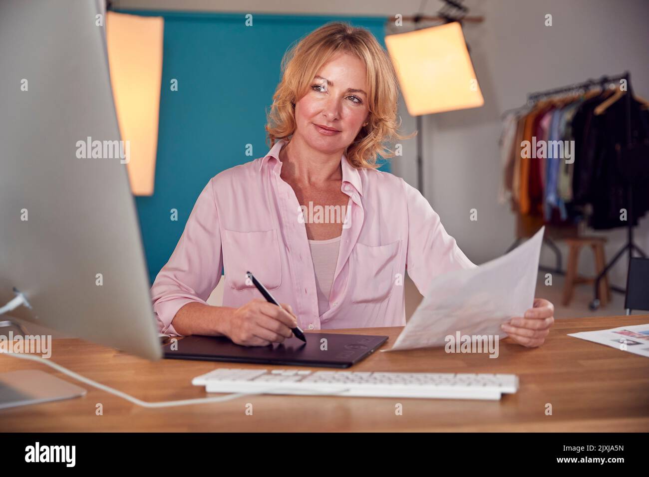 Fotografo professionista Designer o Retoucher alla scrivania che lavora su immagini su computer in Studio Foto Stock