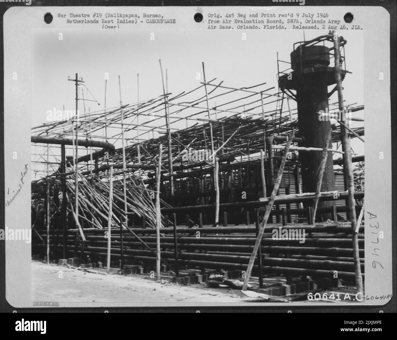 Pali di bambù sparsi sopra la cima di un'unità di condensatore in una pianta di acido solforico, servito molto efficacemente come mimetizzazione. Balikpapan, Borneo-4 agosto 1945. Foto Stock