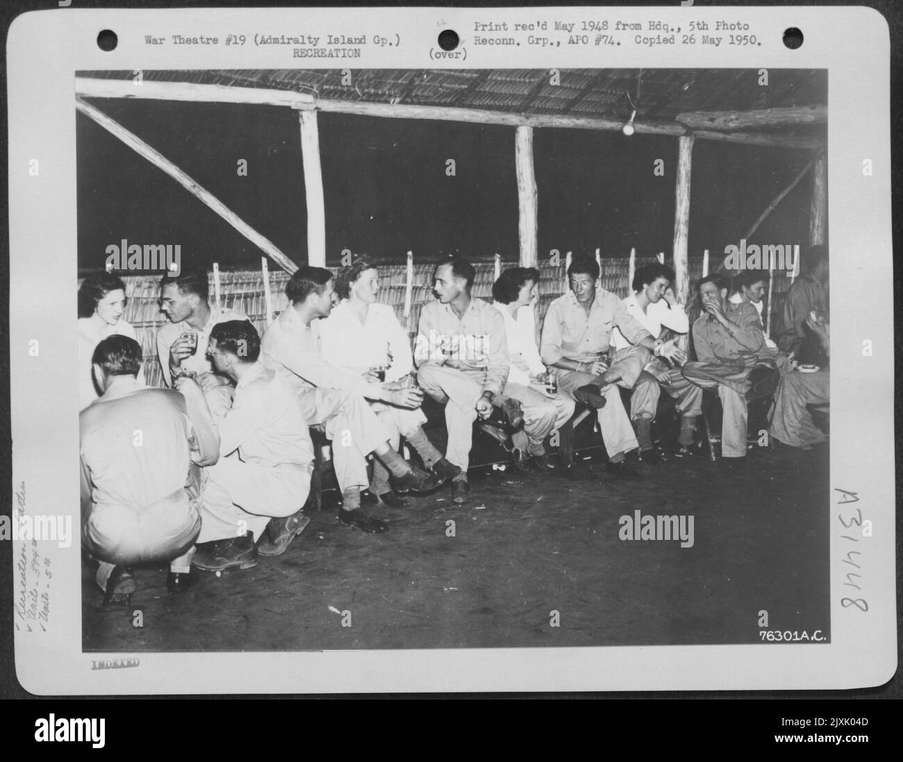 I membri dello Squadrone della bomba del 394th, del gruppo della bomba del 5th 'Baroni bombardieri', conversano con le infermiere in un partito che hanno dato ad una base aerea sulle isole dell'Ammiragliato. 19 giugno 1944. Foto Stock