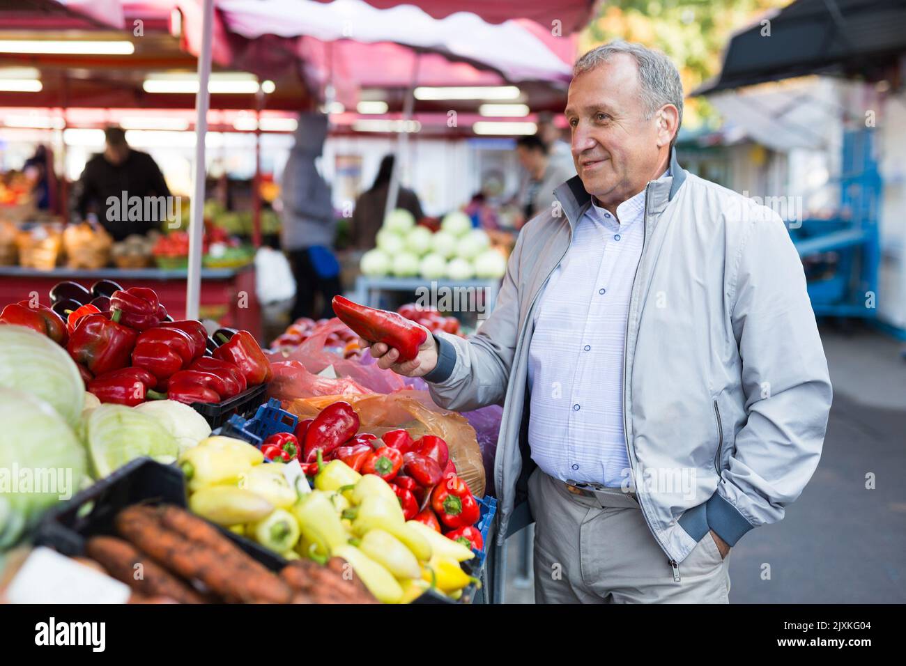 Uomo di mezza età che acquista peperoni Foto Stock