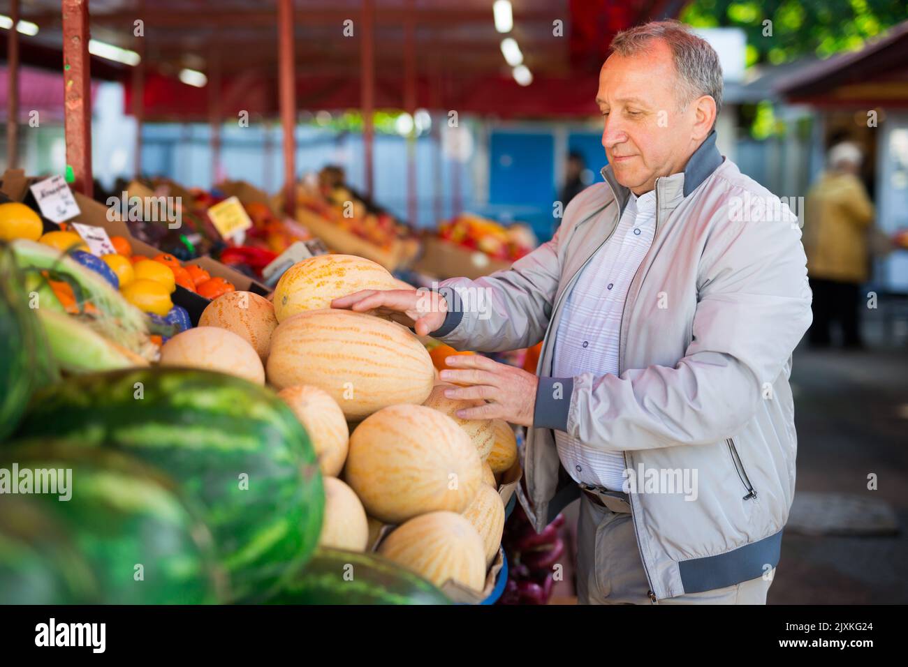 Uomo di mezza età che acquista melone Foto Stock