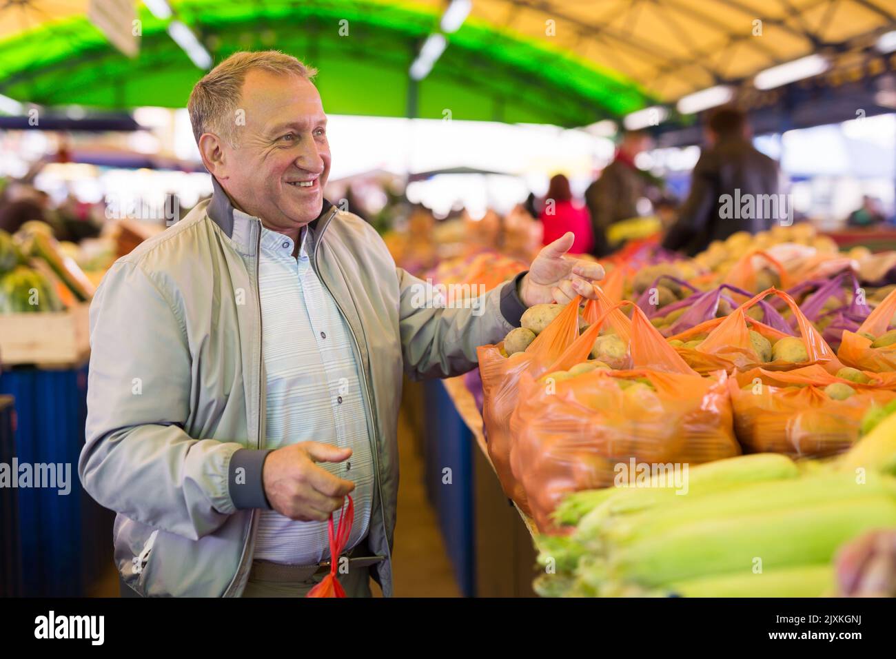 Uomo che acquista patate sul mercato Foto Stock