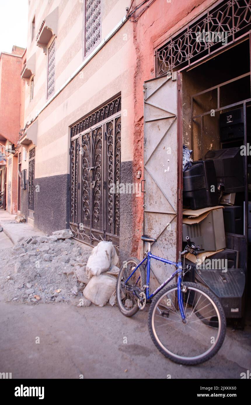 Porta in metallo antico, macerie e una bicicletta a Marrakech, Marocco Foto Stock
