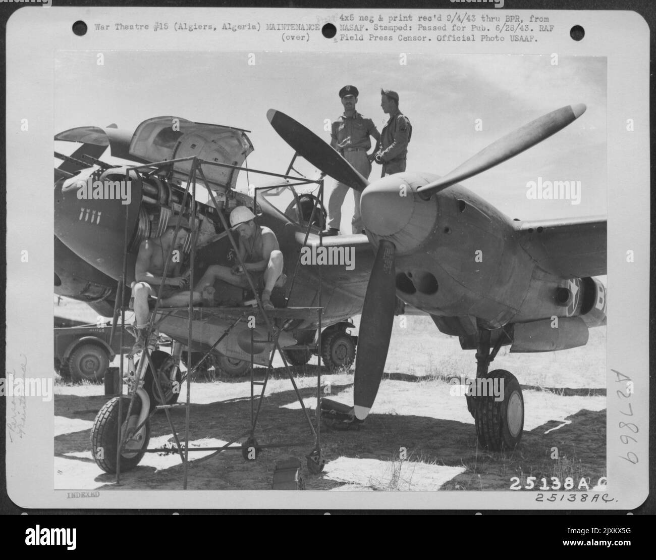 Da L a R: SGT. Leroy Garman (Redding, Pa.) e CPL. Wendal Stoltz (Sumner, Ill.) lavora sull'aereo, mentre 1st Lt. Lawrence P. Liebers (Burbank, Calif.) Lockheed P-38 pilota, parla con il suo equipaggio, T/Sgt. Roswell Harding (Fenton, Michigan.) sul Foto Stock