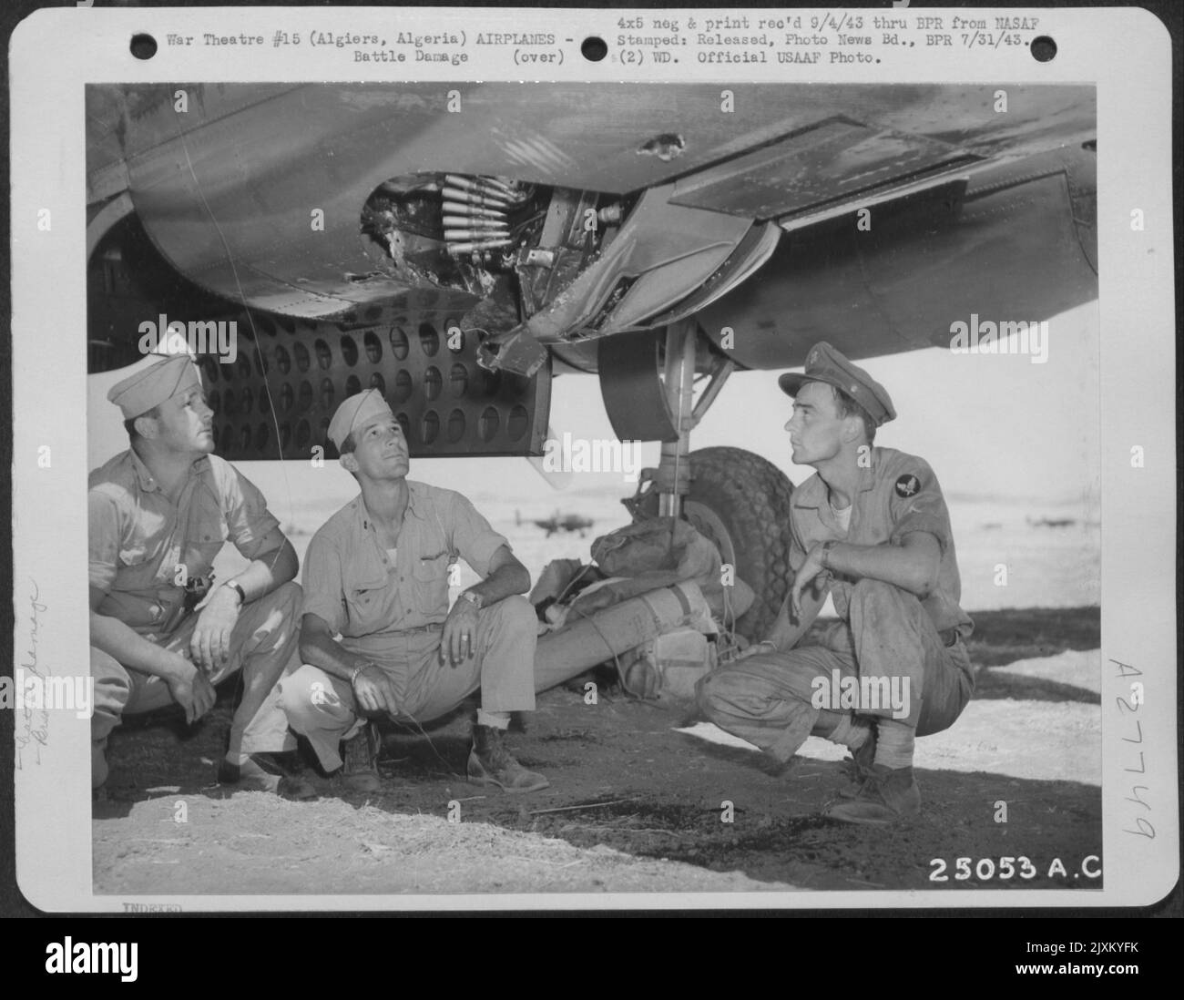Algeri, Algeria-13 luglio 1943. Il timone posteriore destro frantumato e lo stabilizzatore sono stati tra i più gravi dei 500 fori di un bombardiere Mitchell B-25, che è tornato da Gerbini, in Sicilia. I membri rimanenti vengono mostrati esaminando le parti infortunate. Da sinistra a. Foto Stock