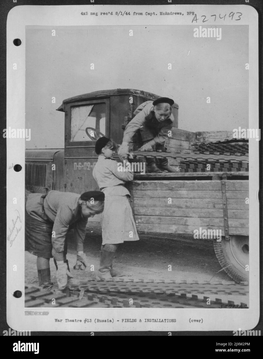 Tre ragazze dell'Armata Rossa Russa scaricano e montano matting in acciaio per formare piste per i pesanti bombardieri delle forze aeree strategiche degli Stati Uniti che scacciano in URSS dall'Inghilterra e dall'Italia e bombardano obiettivi in rotta. Queste ragazze hanno lavorato a lungo e duro e non hanno contato Foto Stock