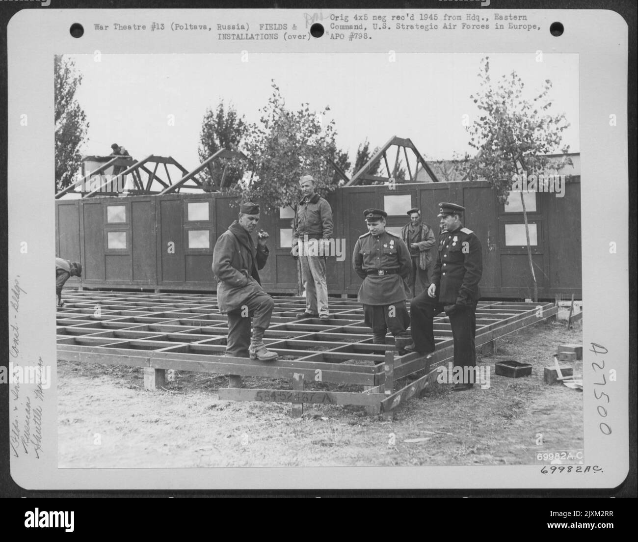 Il personale russo e americano ispeziona la costruzione di caserme in corso presso la base aerea Poltava in Russia. La caserma ospiterà personale che parteciperà alle missioni di shuttle russo durante l'inverno del 1944. Foto Stock