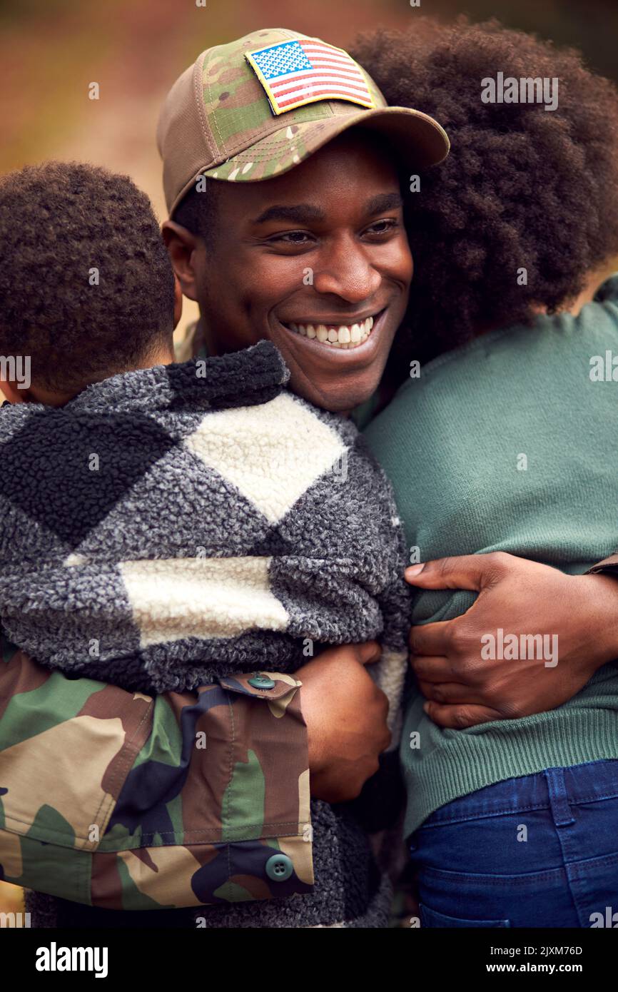 Soldato americano in uniforme ritorno a casa in partenza per la famiglia salutato da due bambini Foto Stock