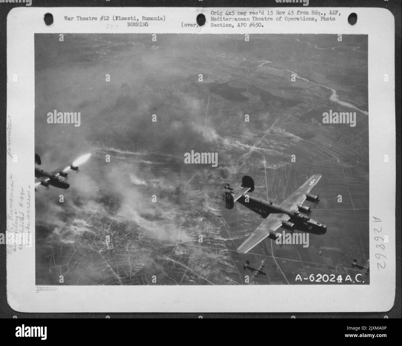 Bombe esplose sulla raffineria petrolifera a Ploesti, in Romania, durante un attacco dei liberatori consolidati B-24 delle forze aeree del 15th. Il bersaglio è parzialmente oscurato da Una schermata fumo. Foto Stock