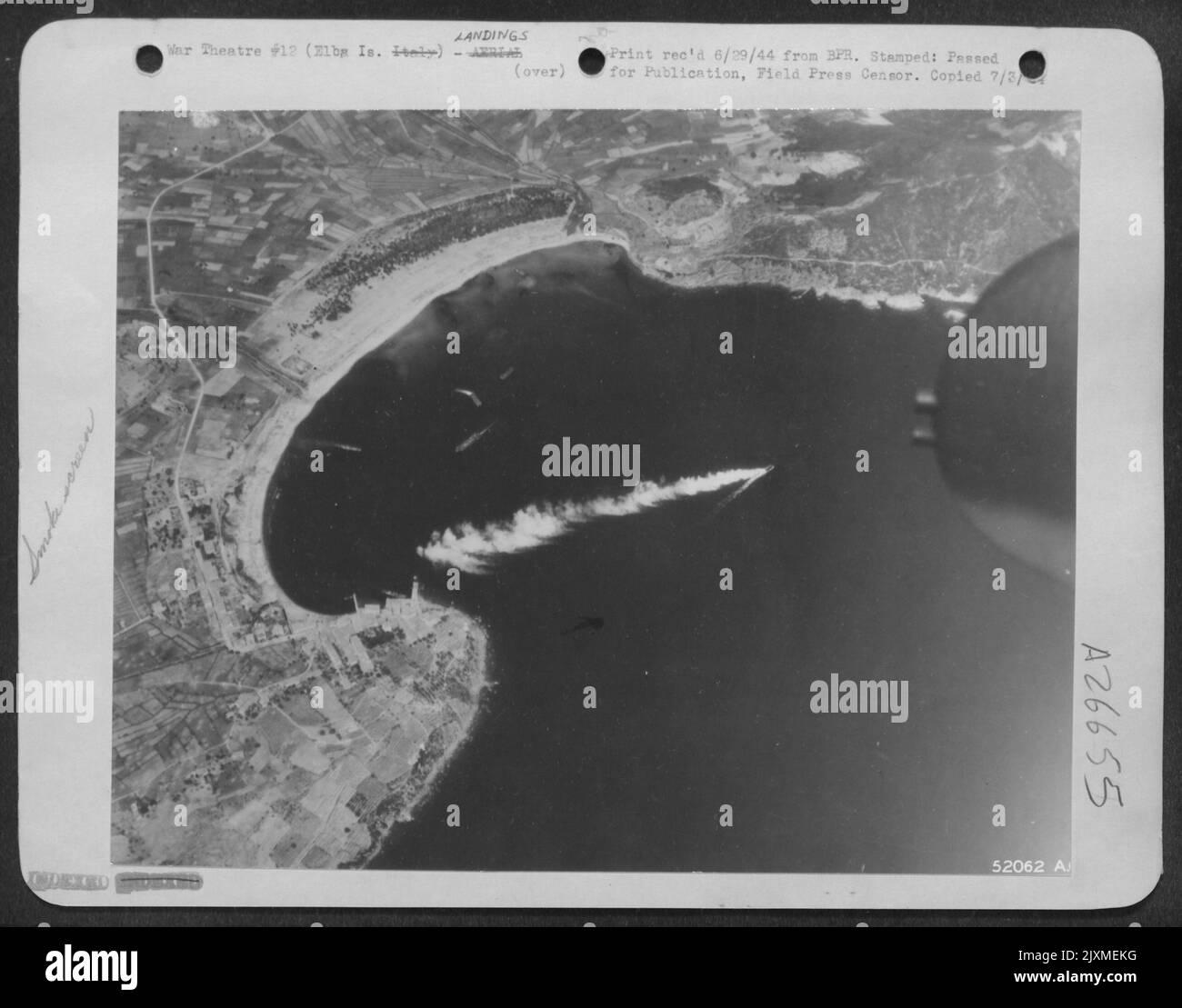 Le forze francesi combattenti sono mostrate in questa fotografia aerea mentre atterrano sull'isola d'Elba sotto la copertura protettiva dell'aeronautica alleata del Mediterraneo. Una protezione di fumo può essere vista essere posata da un'imbarcazione di atterraggio mentre si avvicina alla riva. Foto Stock