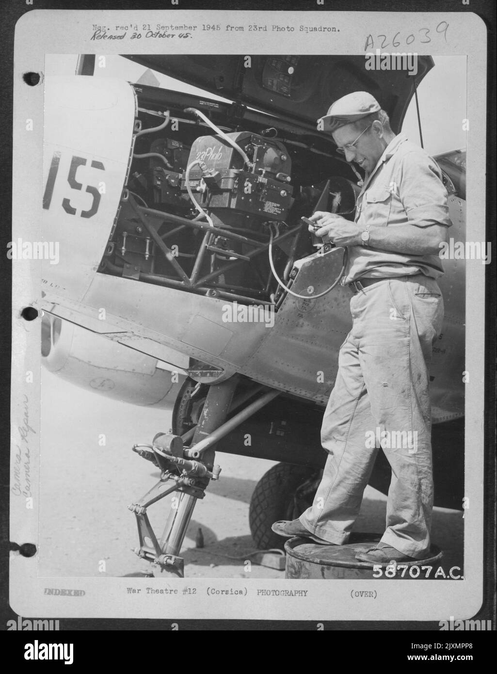 Tecnico della telecamera al lavoro sulla telecamera sul naso di Lockheed P-38. CORSICA. 7 agosto 1945. Foto Stock