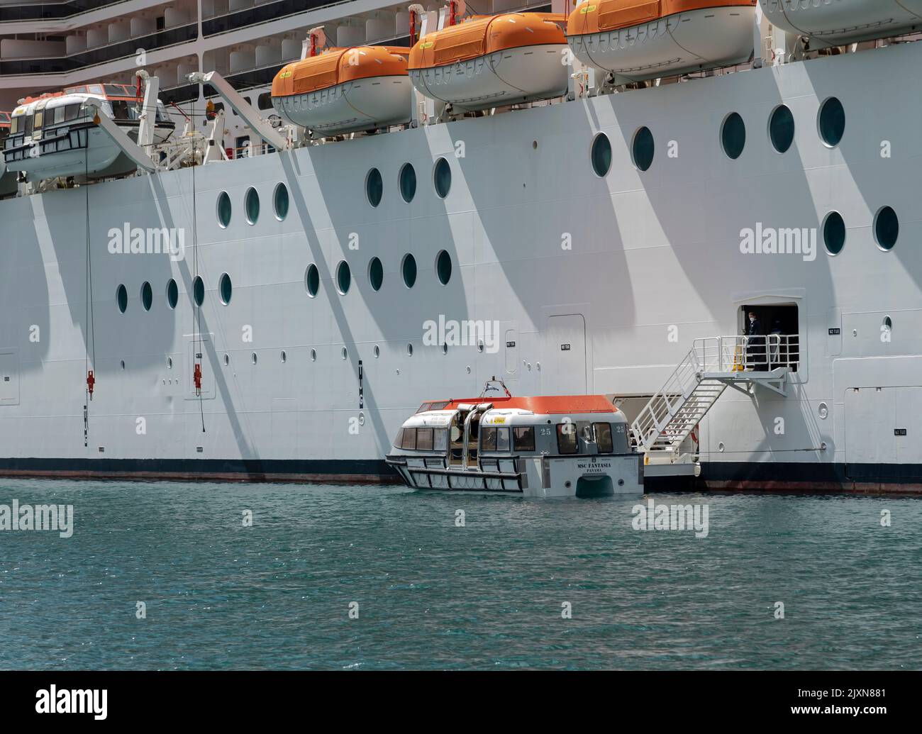 I passeggeri che arrivano a bordo di un lussuoso transatlantico sbarcano su una piccola imbarcazione per salire a terra Foto Stock