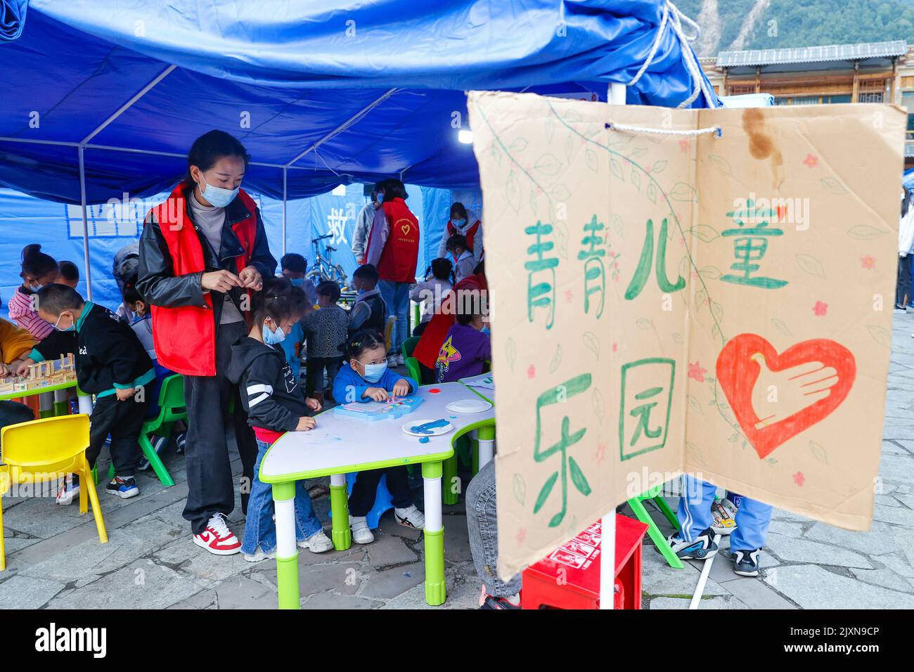 Moxi, la provincia cinese del Sichuan. 7th Set, 2022. I bambini giocano con i volontari in un centro per bambini in un rifugio di soccorso sul terremoto nella città di Moxi, nella contea di Luding, nella provincia sudoccidentale del Sichuan, il 7 settembre 2022. Un centro per bambini è stato costruito in un rifugio di soccorso sul terremoto a Moxi Town per prendersi cura dei bambini colpiti dal terremoto. Credit: Shen Bohan/Xinhua/Alamy Live News Foto Stock