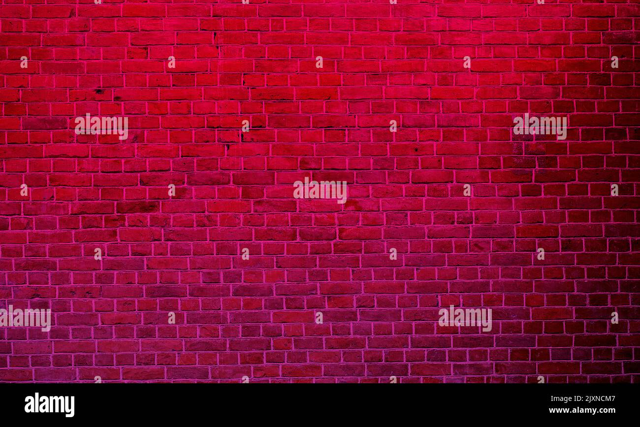 Luce rossa al neon sopra la lunga parete in mattoni vintage Foto Stock