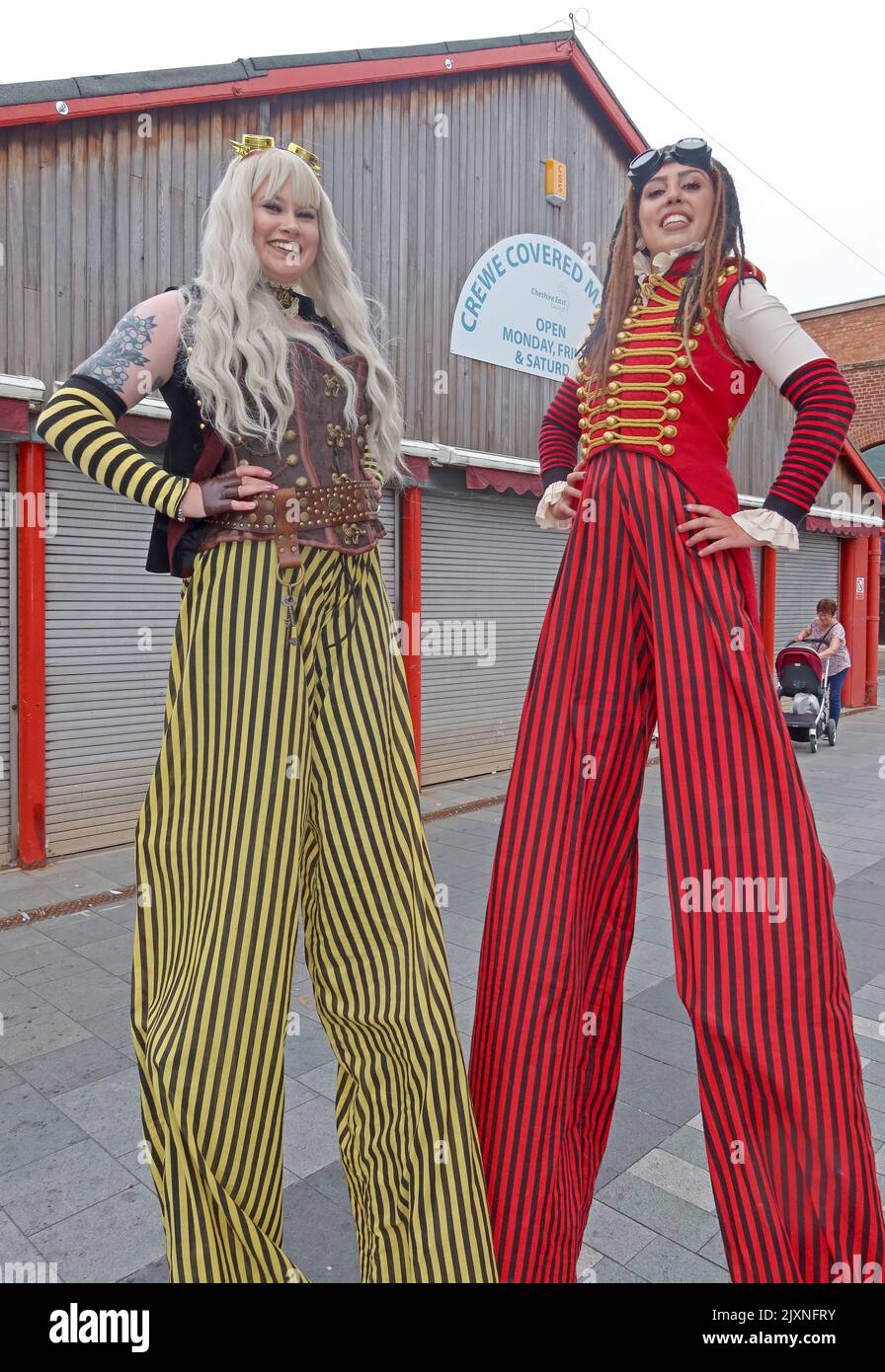 Due stiltwalkers lady al mercato coperto di Crewe Foto Stock