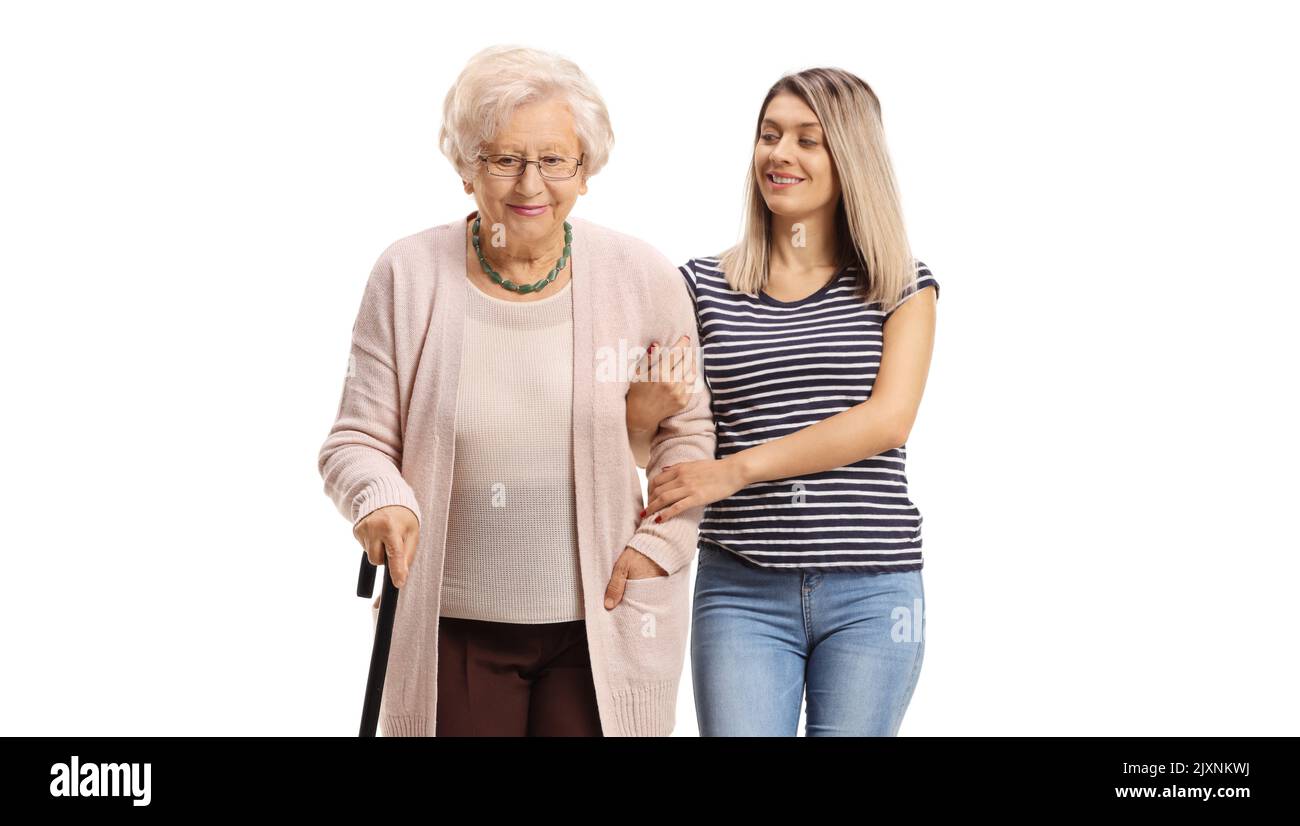Giovane donna che aiuta una donna anziana a camminare con una canna isolata su sfondo bianco Foto Stock