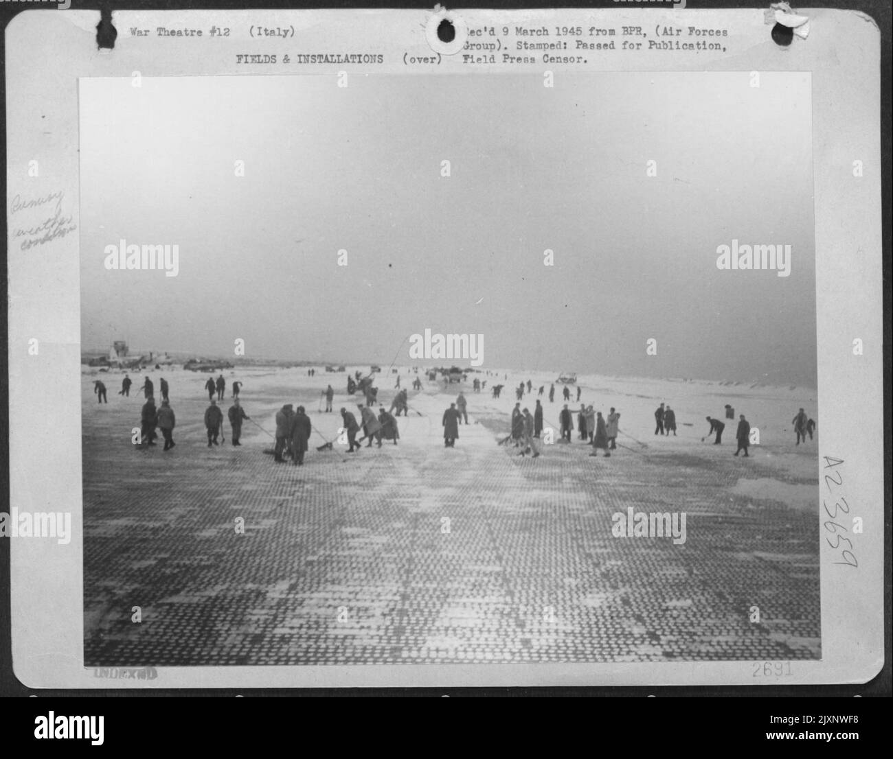L'entità del lavoro che gli ingegneri aeronautici americani devono affrontare dopo Una tempesta di neve in volo su questo campo aereo sotto il livello del mare in Italia può essere vista da questa pista che viene bonificato. Due ore prima il campo fu sepolto nella neve. Ma gli ingegneri hanno reso possibile la Fo Foto Stock