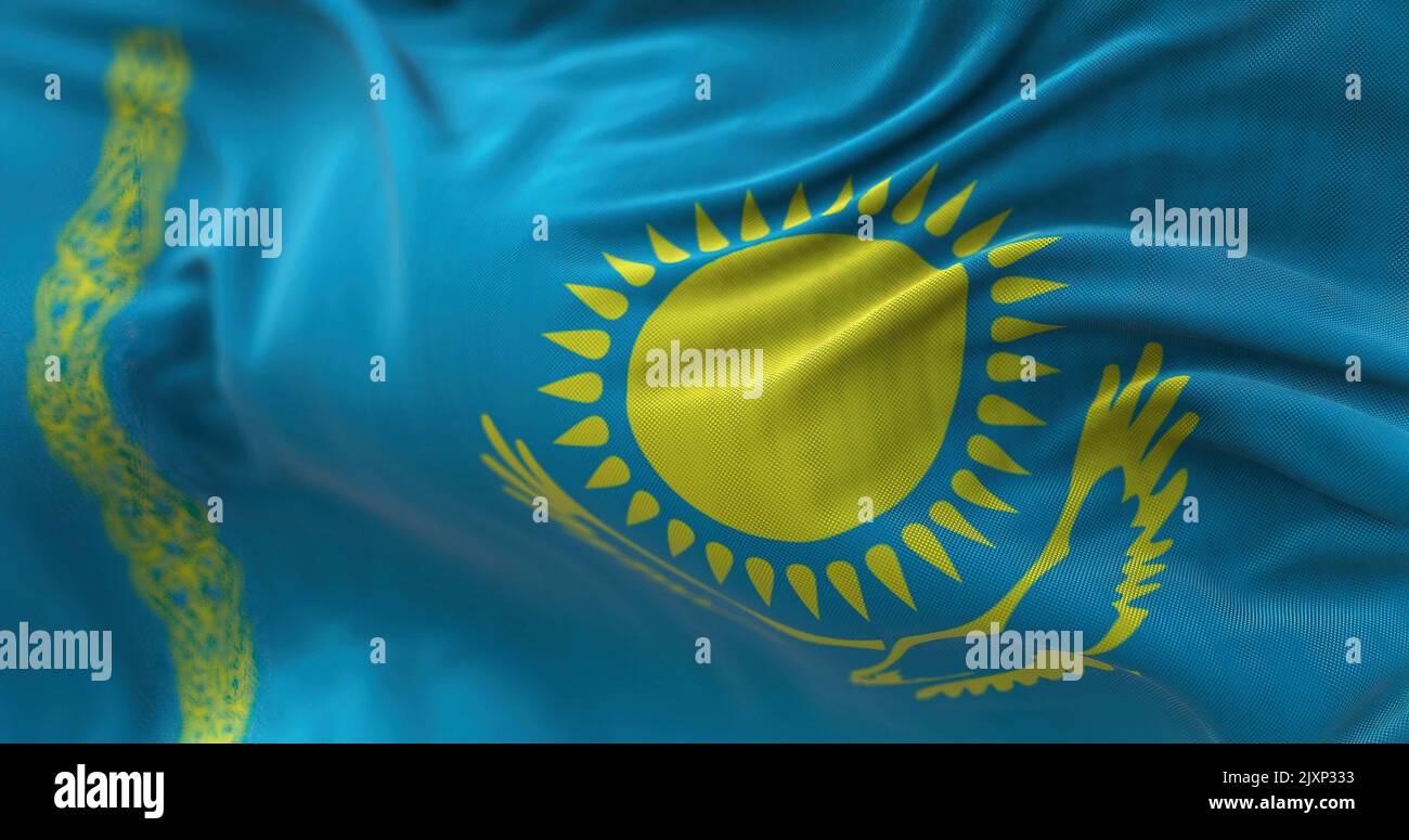 Vista ravvicinata della bandiera nazionale del Kazakistan che sventola nel vento. Il Kazakistan è un paese transcontinentale situato principalmente in Asia e in parte in Europa Foto Stock