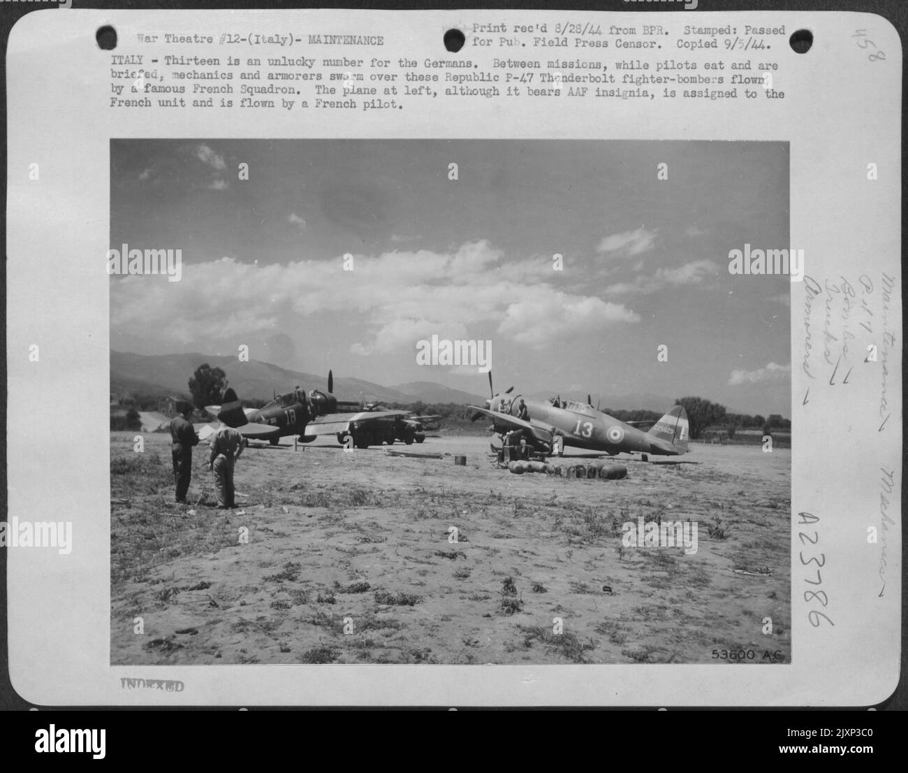 ITALIA--tredici è un sfortunato per i tedeschi. Tra le missioni, mentre i piloti mangiano e vengono informati, meccanici e corazzatori si sciarmano su questi combattenti-bombardieri Republic P-47 Thunderbolt volati da un famoso Squardron francese. Il piano a sinistra, anche se Foto Stock