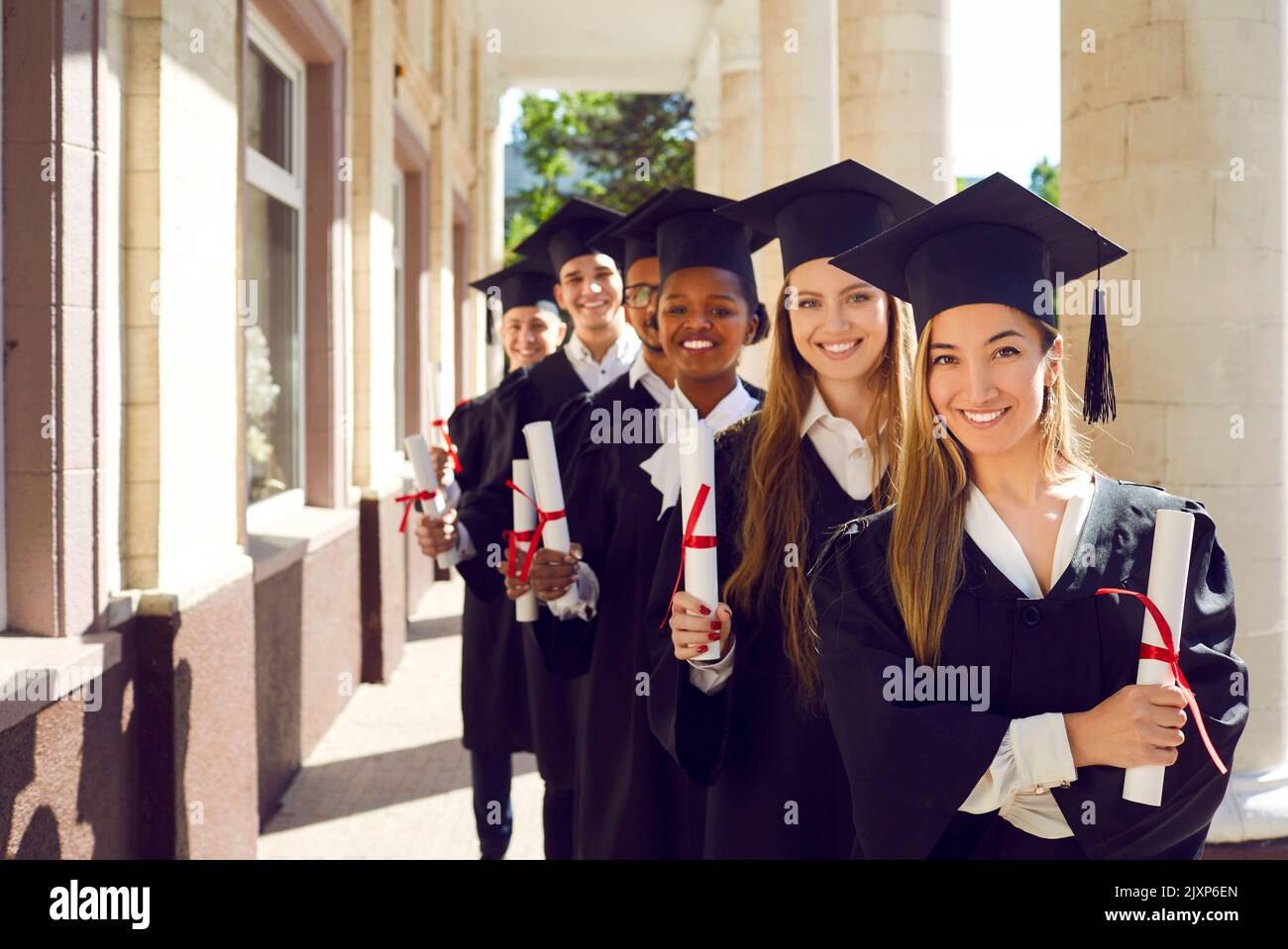 Ritratto di laureati felici di sesso femminile e maschile in possesso di diplomi di istruzione superiore. Foto Stock