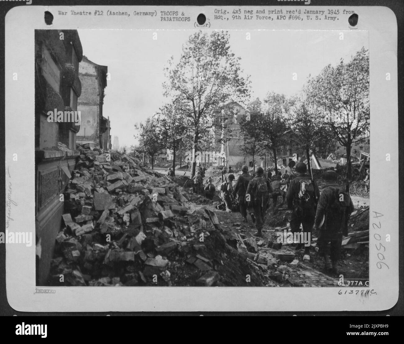A seguito Di Un preliminare ammorbidimento da artiglieria carri armati-cacciatorpediniere e 9th AF Dive Bombers Hank Fanttrymen sono mostrati avanzare nella città di Aquisgrana, Germania. Foto Stock