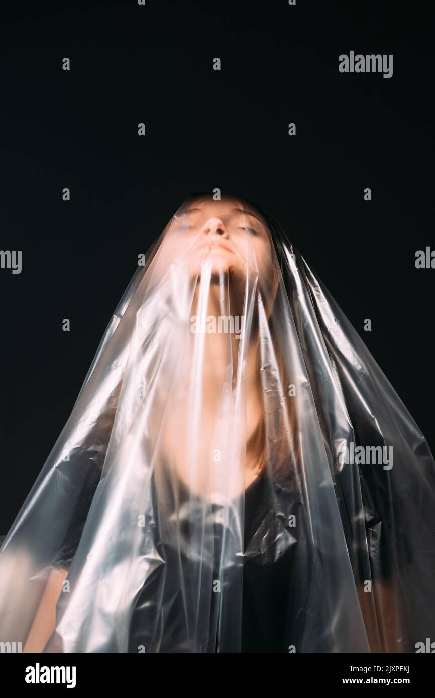 plastica inquinamento donna sacchetto in polietilene nero Foto Stock