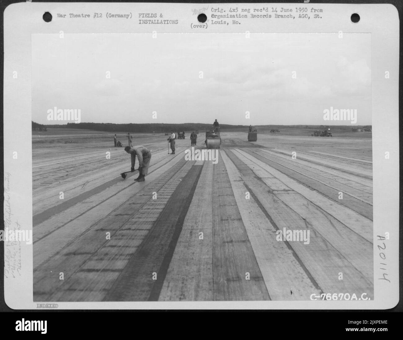Gli uomini del Battaglione di Aviazione del 834Th costruiscono Una striscia di atterraggio a Buchschwabach, Germania, con il 'mat hessiano' usato per la superficie. Il tappetino, Una composizione simile a Tar-Paper, viene posato da camion caricati con rotoli da 200 piedi. UN 50%%%%%%%%% La sovrapposizione viene mantenuta a. Foto Stock