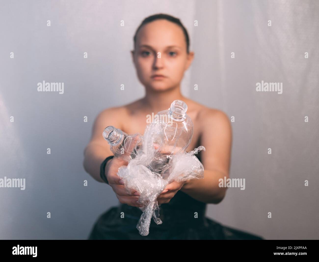 plastica inquinamento defocused donna bottiglia usata Foto Stock